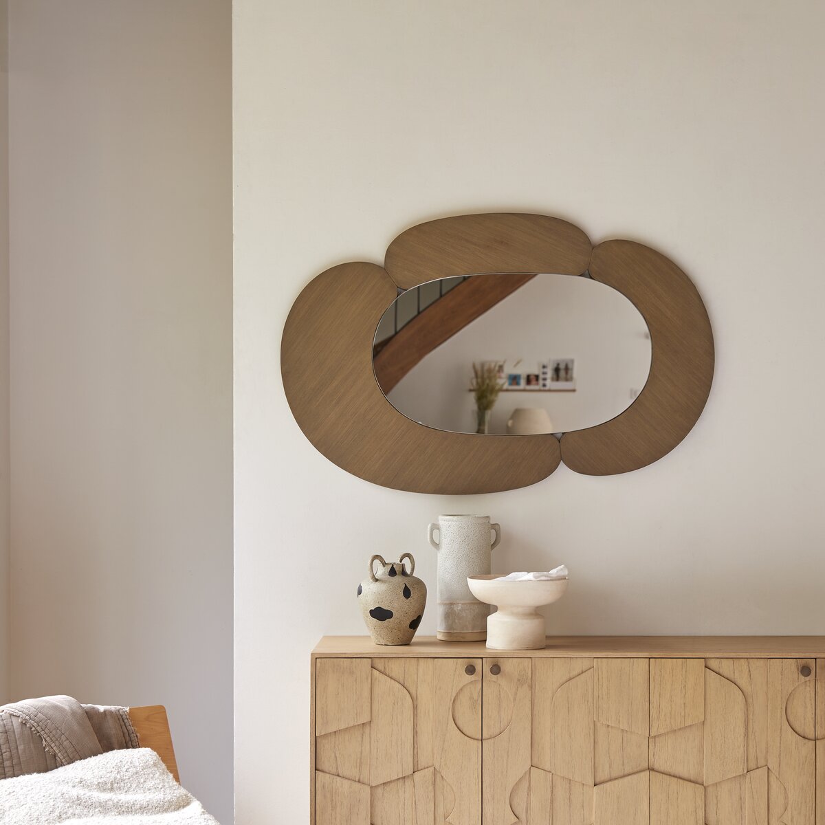 espelho oval com moldura abstrata de madeira