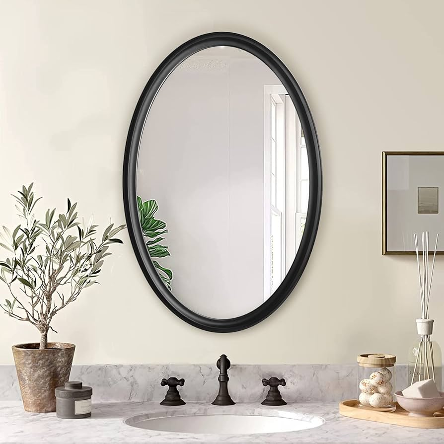 espelho oval com moldura preta em banheiro