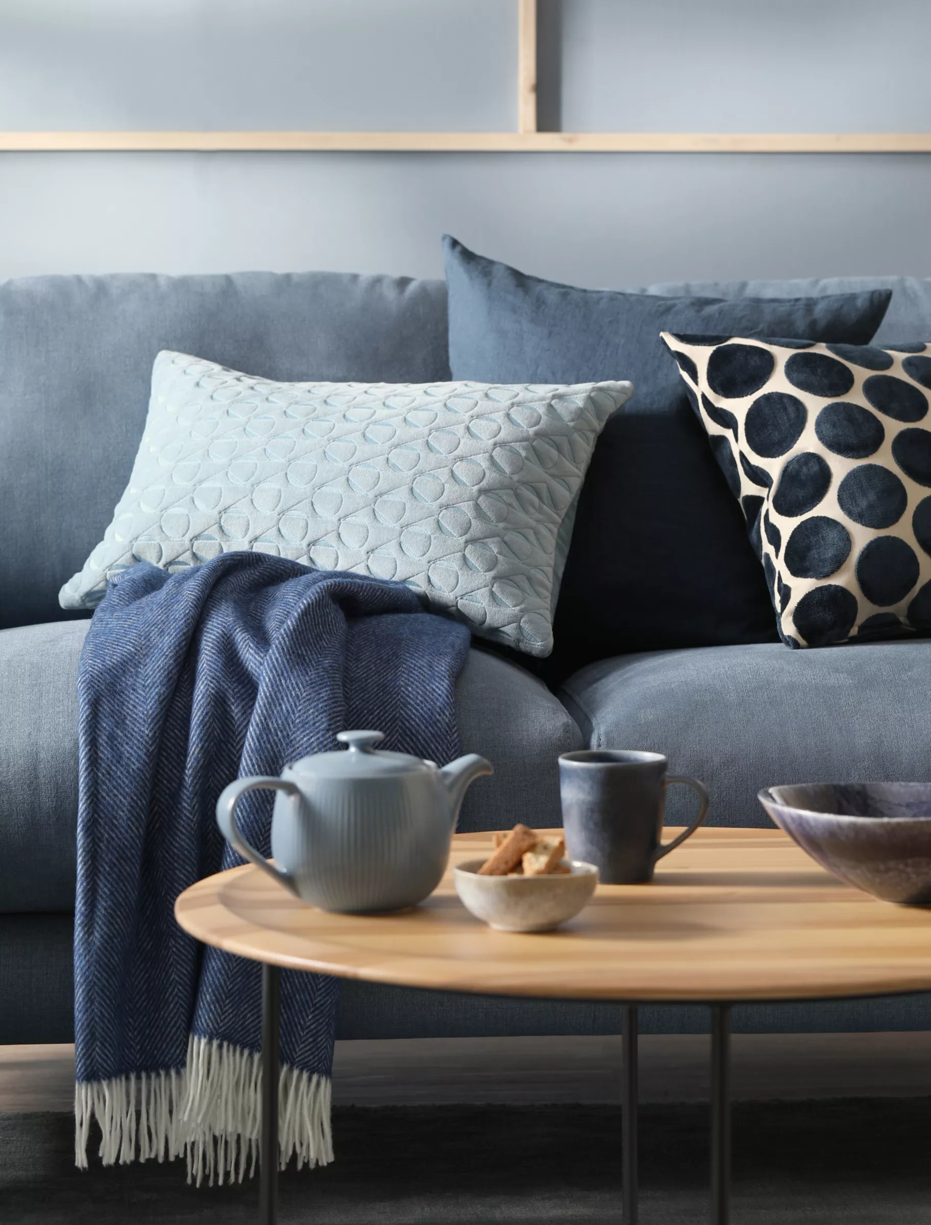 sofá, almofadas e manta azuis